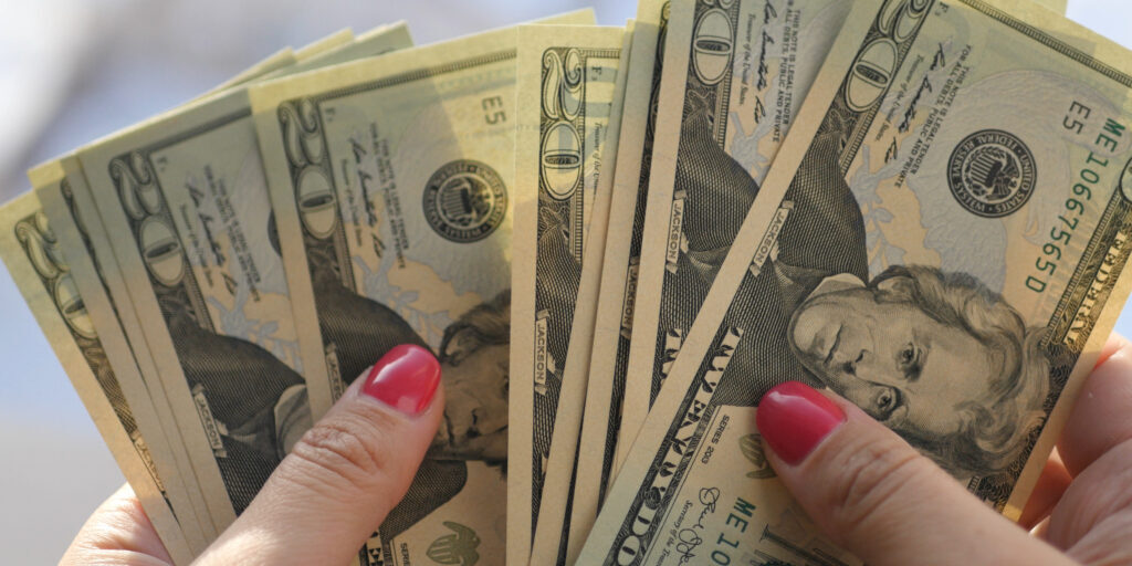 Girl looks at the new twenty-dollar bills in her hands, HD